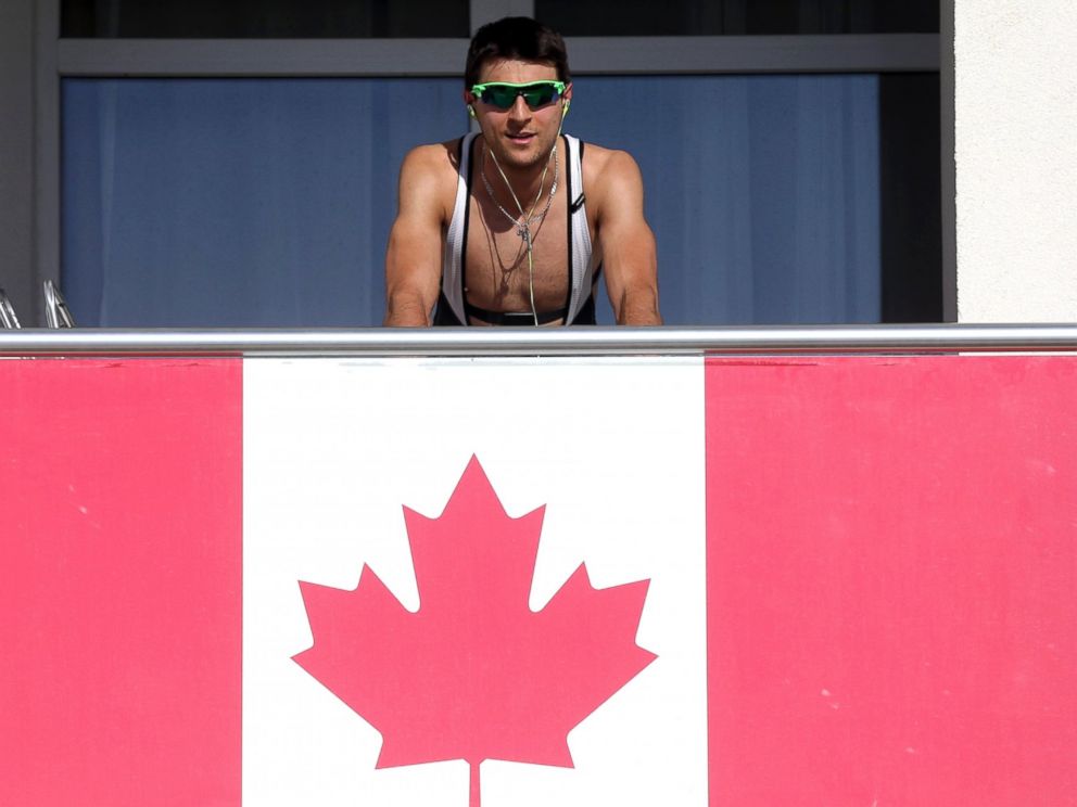 PHOTO: A member of the Canadian team takes advantage of warm weather to work out on his balcony in Olympic Village at the Winter Olympics in Sochi, Russia, Feb. 6, 2014.
