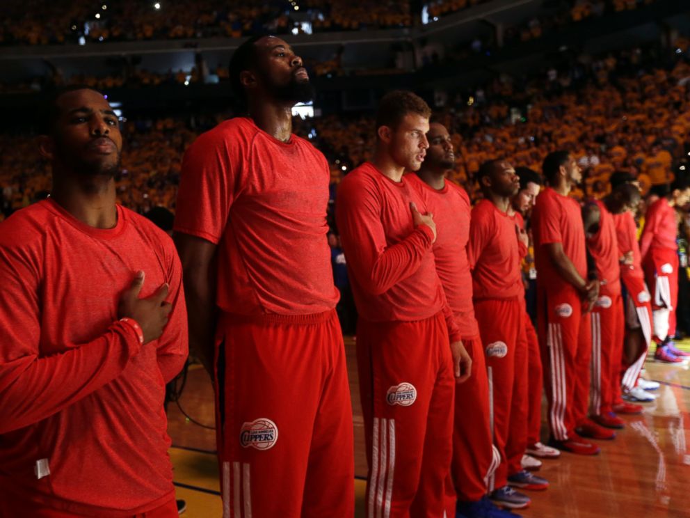 PHOTO: Members of the Los Angeles Clippers listen to the national anthem before Game 4 of an opening-round NBA basketball playoff series against the Golden State Warriors on Sunday, April 27, 2014, in Oakland, Calif.