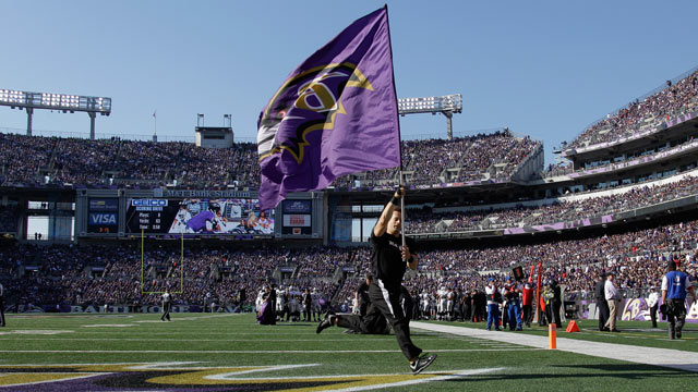 PHOTO: A Baltimore Ravens cheerleader carries the teams flag on the field before the start of the Ravens game against the Oakland Raiders at M&T Bank Stadium, Nov. 11, 2012, in Baltimore.