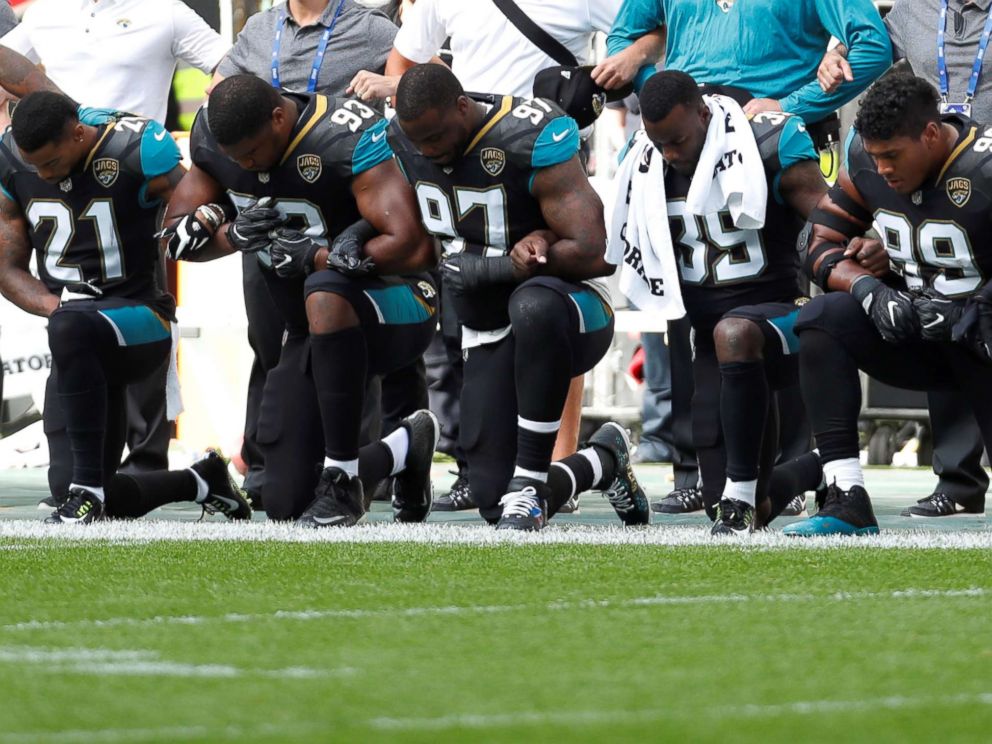 PHOTO: Jacksonville Jaguars players lock arms and kneel down during the playing of the U.S. national anthem before an NFL football game against the Baltimore Ravens at Wembley Stadium in London, Sunday Sept. 24, 2017. 