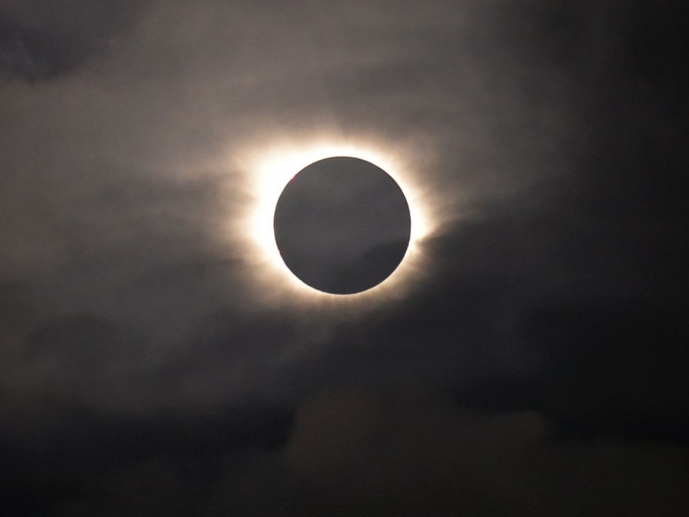 PHOTO: A total solar eclipse is visible through the clouds as seen from Vagar on the Faeroe Islands, March 20, 2015.