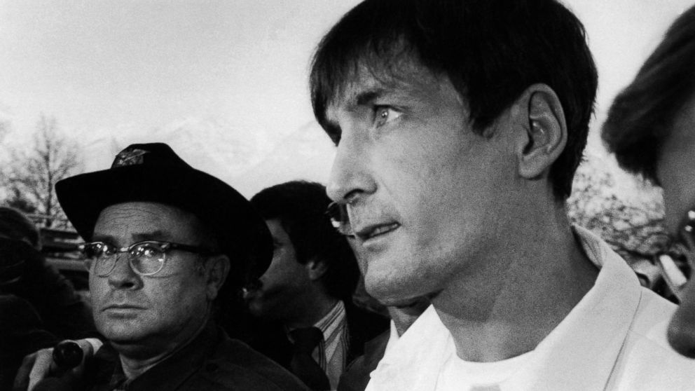 PHOTO: Gary Gilmore, wearing prison maximum security white uniform, faces barrage of newsmen and law enforcement officers on way to 4th District Court for new execution date in Provo, Utah, Dec. 3, 1976.
