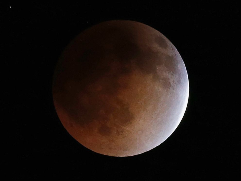 PHOTO: The moon turns an orange hue during a total lunar eclipse in the sky above Phoenix