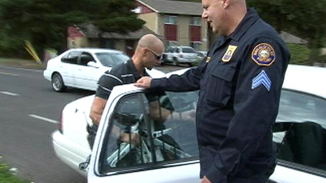 PHOTO: Portland police Stg. Dan Slauson and officer Jason Lobaugh put a stolen bike recovered from a Craigslist sting in the back of a squad car.