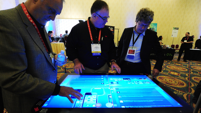 PHOTO: People sample a 3M Touch Systems 46-inch PCT-display demonstrating the scalability of projective capacitive technology at CES Unveiled, ahead of the opening of the annual Consumer Electronics Show, Jan. 8, 2012 in Las Vegas, Nevada.
