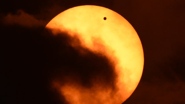 PHOTO: Clouds partially obscure the sun during the transit of Venus on June 5, 2012 as seen from Riverside Park on the west side of Manhattan in New York.
