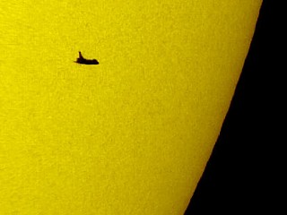 Photo: The space shuttle Atlantis silhouetted against the Sun.