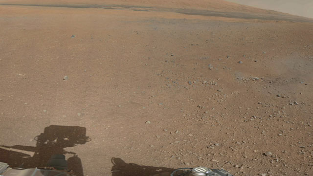 PHOTO: The first color panorama from the Mars rover Curiosity shows a desert plain in the foreground, and the rim of a crater on the horizon.