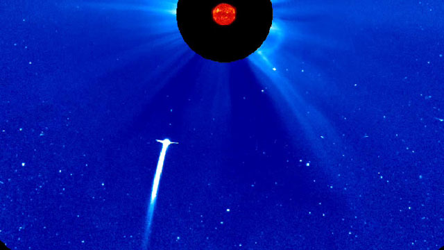 PHOTO: Comet Lovejoy plunging toward the sun, as seen by NASAs SOHO spacecraft. The image is in false color. The sun is blocked by a disc so that its light will not drown out everything around it.