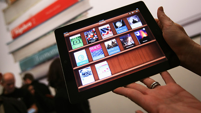 PHOTO: A woman holds up an iPad, with iBooks textbooks shown in the iTunes U app, after a news conference introducing a digital textbook service, Jan. 19, 2012, in New York.