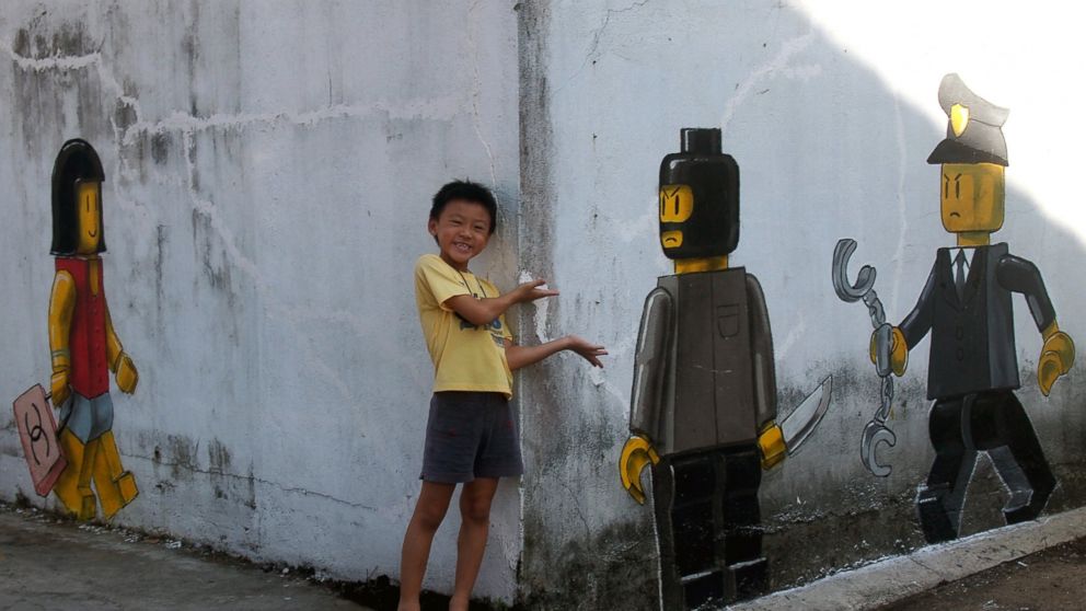 PHOTO: Lithuanian artist Ernest Zacharevics controversial mural depicts a Lego woman with a Chanel bag , a Lego robber with a knife on a wall in Johor Bahru, Malaysia.