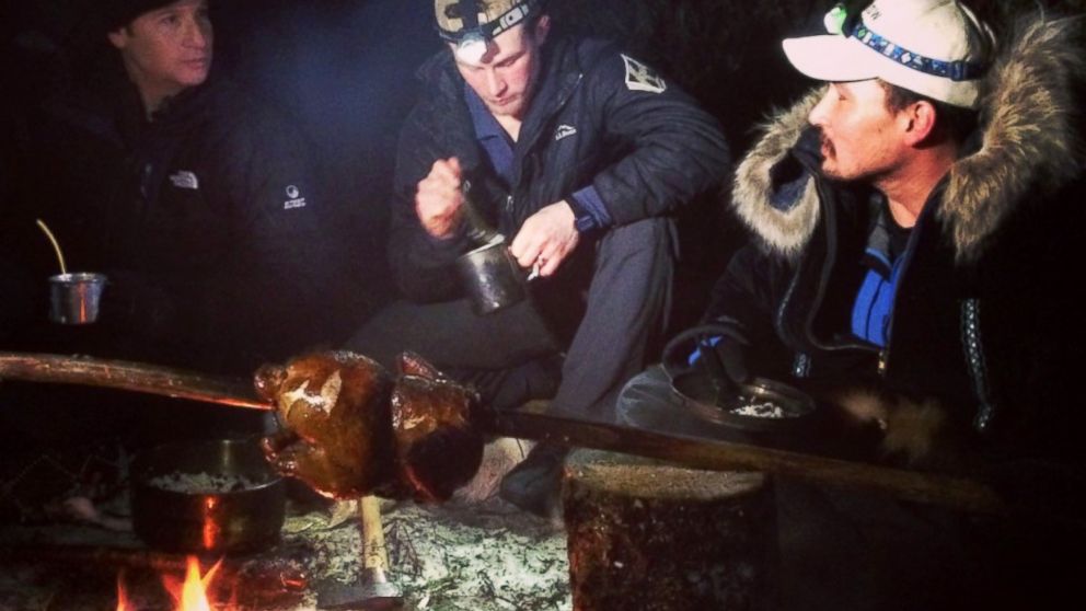 PHOTO: ABCs Neal Karlinsky, left, Dallas Seavey, center, and Eddie Ahyakak, right, sit around a campfire in the Alaskan wilderness.