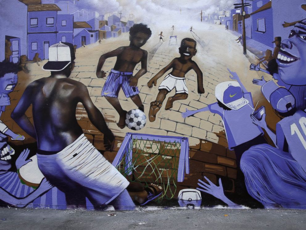 PHOTO: A wall decorated with a mural depicting children playing soccer at street in a favela stands in Rio de Janeiro, Brazil, May 27, 2014.