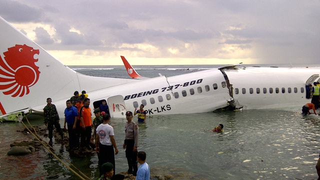 PHOTO: Rescuers stand near the wreckage of a crashed Lion Air plane in Bali, Indonesia on Saturday, April 13, 2013.