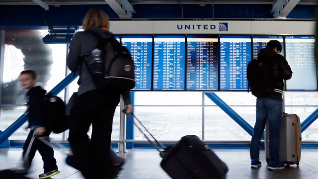 PHOTO: In this Dec. 21, 2012, file photo, travelers walk in front of an United Airline flight information screen at O'Hare airport in Chicago.