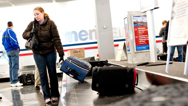 PHOTO: Passengers pick up their bags off the baggage claim belt at O'Hare International Airport in Chicago, Ill., Jan. 19, 2012.