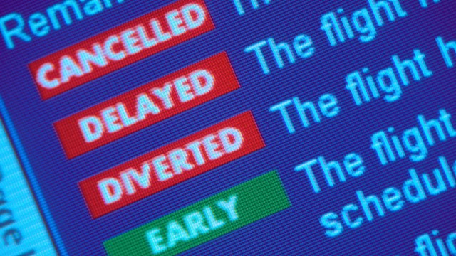 PHOTO: A departure board at the airport shows delays and cancellations.