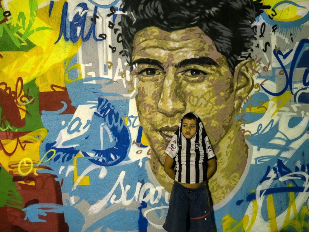 PHOTO: A boy leans on a mural with the portraits of famous football players at Tavares Bastos favela in Rio de Janeiro, Brazil, on May 21, 2014.