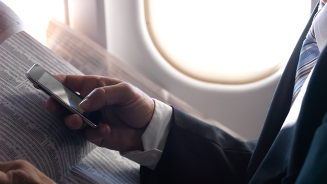 PHOTO: Man using smartphone on airliner