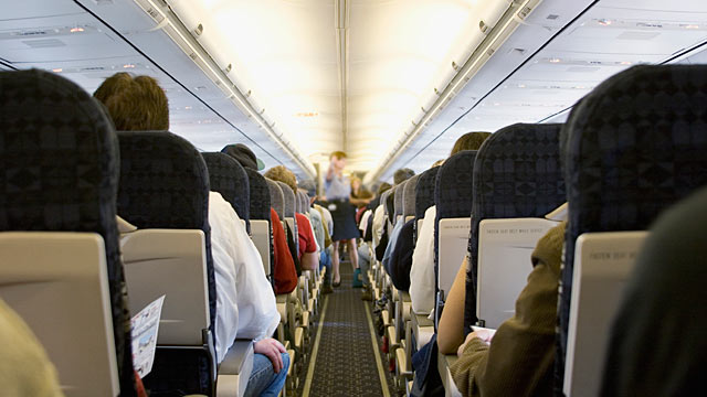 PHOTO: A flight attendant giving instructions in an airplane aisle.