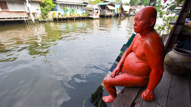 PHOTO: A life-size statue of a pot-bellied man dipping his toe into the water, at the Artists Village in Klong Bang Luong.