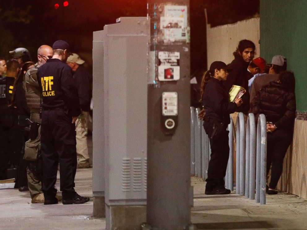 PHOTO: A federal agent questions people in handcuffs during an early morning raid, May 17, 2017, in Los Angeles. Law enforcement agents served arrest and search warrants as part of a three-year investigation into the violent and brutal street gang MS-13.