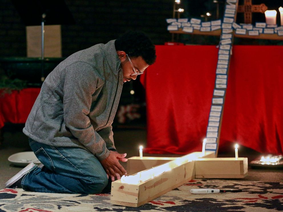 PHOTO: A student lights a candle inside a cross during a vigil at Jacobs Porch, the Lutheran Campus Ministry at Ohio State University in Columbus, Ohio, Nov. 28, 2016.