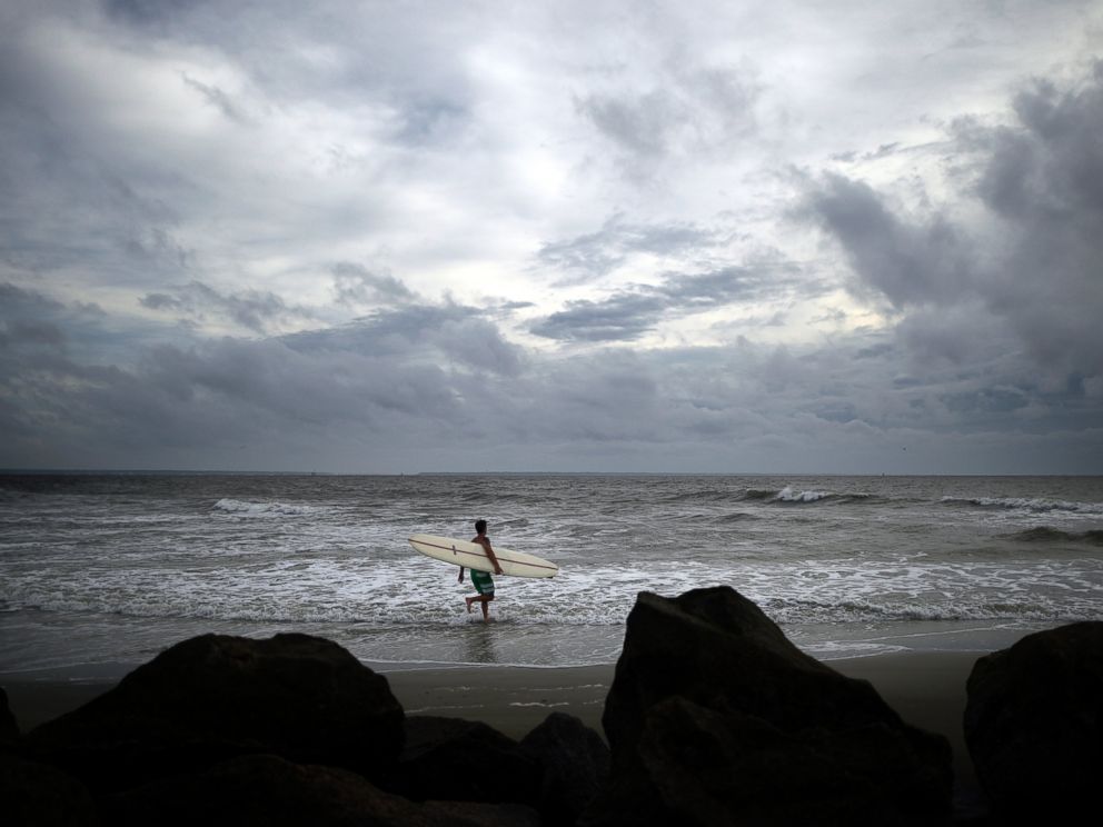 PHOTO: Kevin Taylor of Savannah, Ga., heads out to surf the waves on the north beach of Tybee Island as Hurricane Arthur makes its way up the East Coast, July 3, 2014.