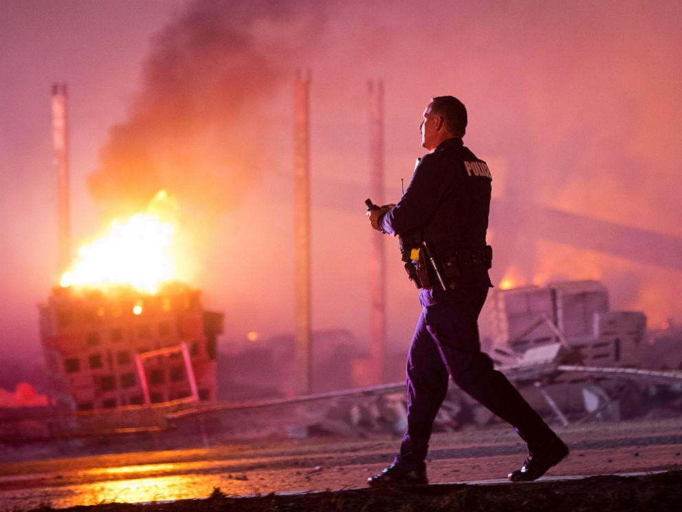 PHOTO: A police officer walks by a blaze, April 27, 2015, after violence broke out in Baltimore.