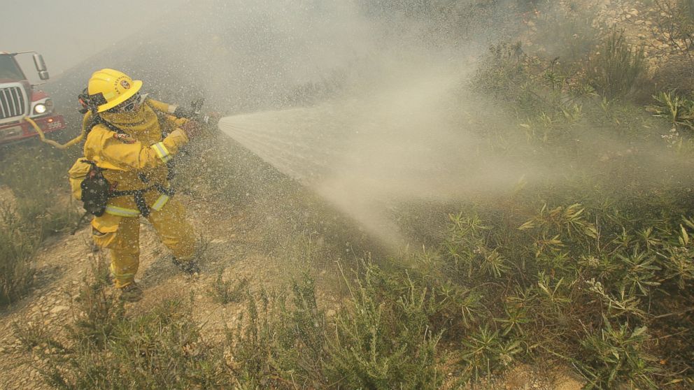 PHOTO: A firefighter sprays down brush as he battles a fire burning in Day Creek near the Etiwanda Preserve in Rancho Cucamonga, Calif., April 30, 2014.