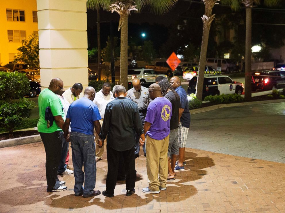 PHOTO: Worshippers gather to pray in a hotel parking lot across the street from the scene of a shooting, June 17, 2015, in Charleston, South Carolina.