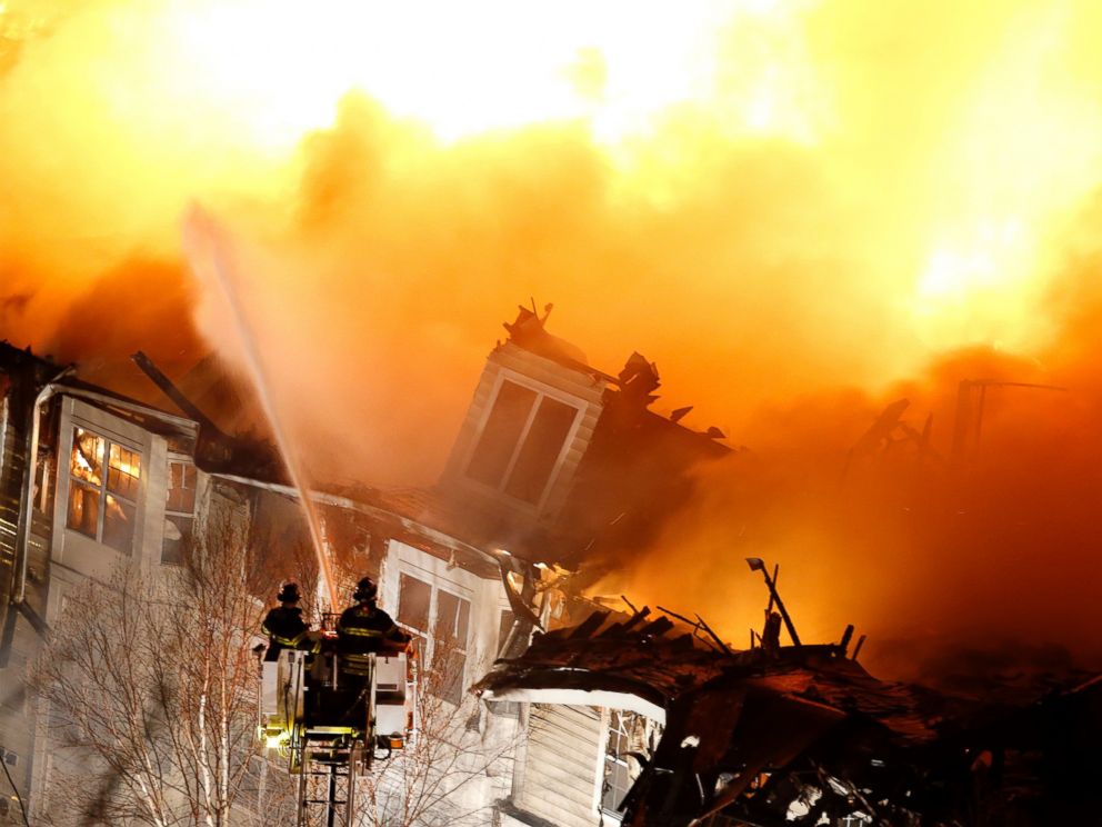 PHOTO: Firefighters stand on a ladder while hosing water onto an apartment complex, Jan. 21, 2015, in Edgewater, N.J.