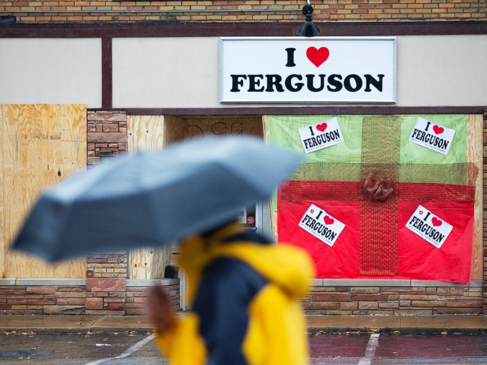 PHOTO: A pedestrian passes a boarded up storefront selling I Love Ferguson paraphernalia, Nov. 23, 2014, in Ferguson, Mo.