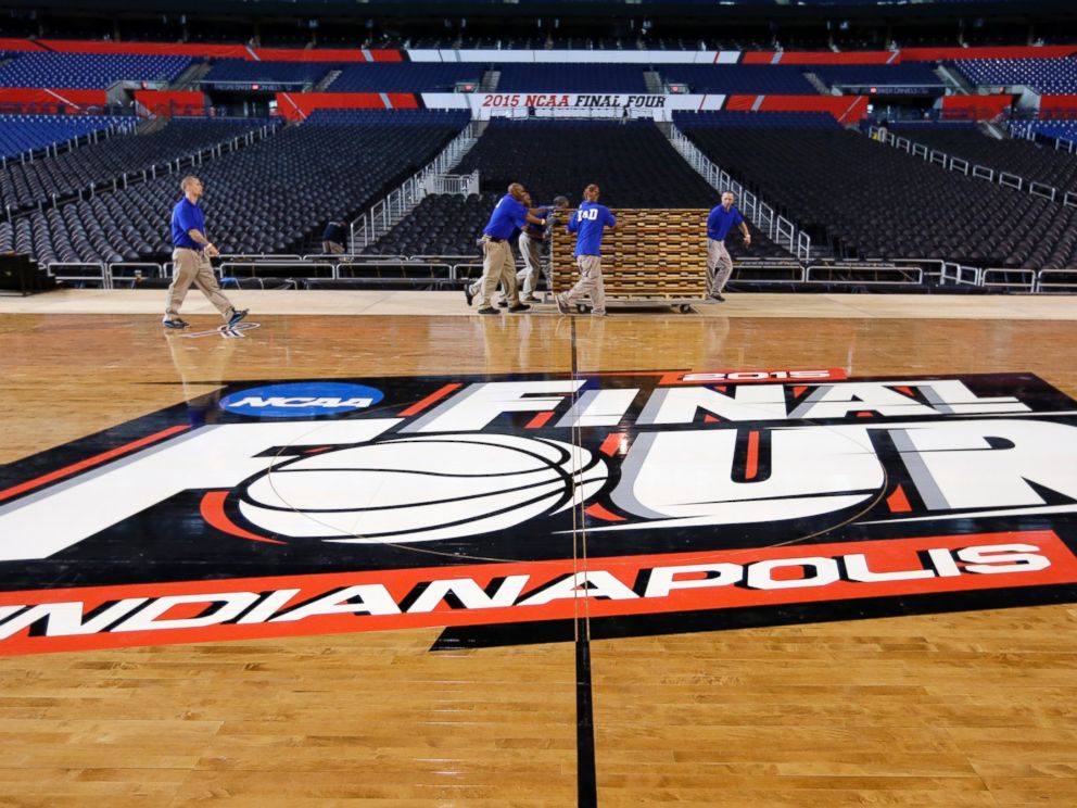 PHOTO: Workers at Lucas Oil Stadium install the court in Indianapolis, March 27, 2015.