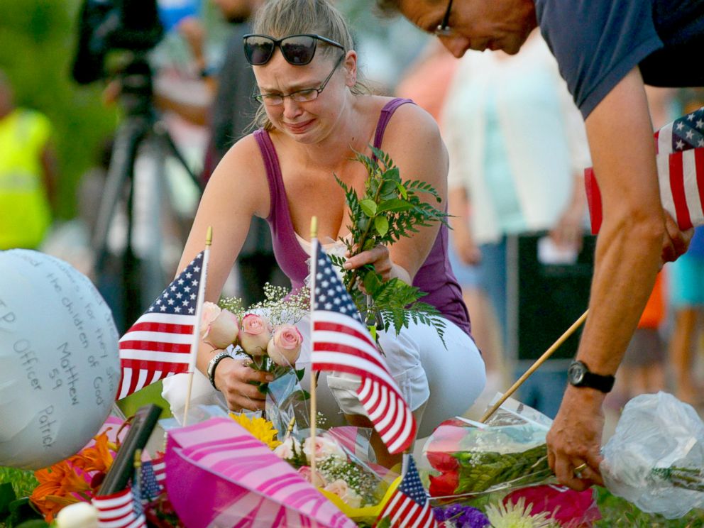 PHOTO: Gail Krull of West St. Paul, Minn. cries as she lays a bouquet of roses on a makeshift memorial following a fatal shooting in West St. Paul, Minn., July 30, 2014.