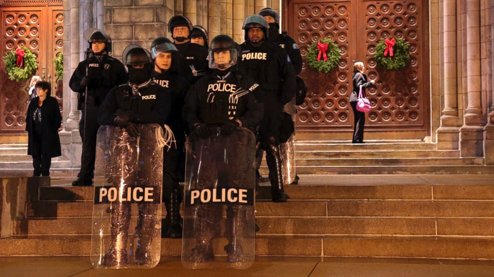 PHOTO: St. Louis Police officers guard the entrance to the Cathedral Basilica before Midnight Mass as protesters held a candlelight vigil, Dec. 24, 2014, in St. Louis.