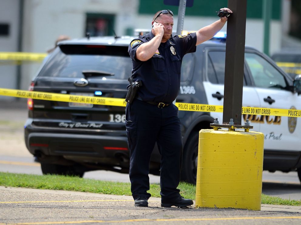 PHOTO: A law enforcement officer speaks on a phone near the site of a shooting in West St. Paul, Minn., July 30, 2014.