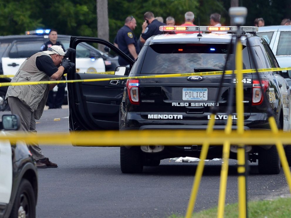 PHOTO: An officer photographs a vehicle driven by a police officer who was shot during a traffic stop in West St. Paul, Minnesota, July 30, 2014.