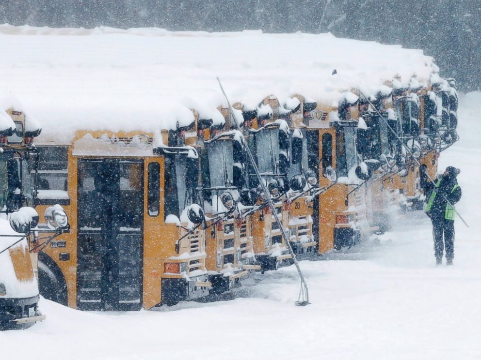 PHOTO: A driver cleans snow off school buses in Derry, N.H., Feb. 2, 2015.