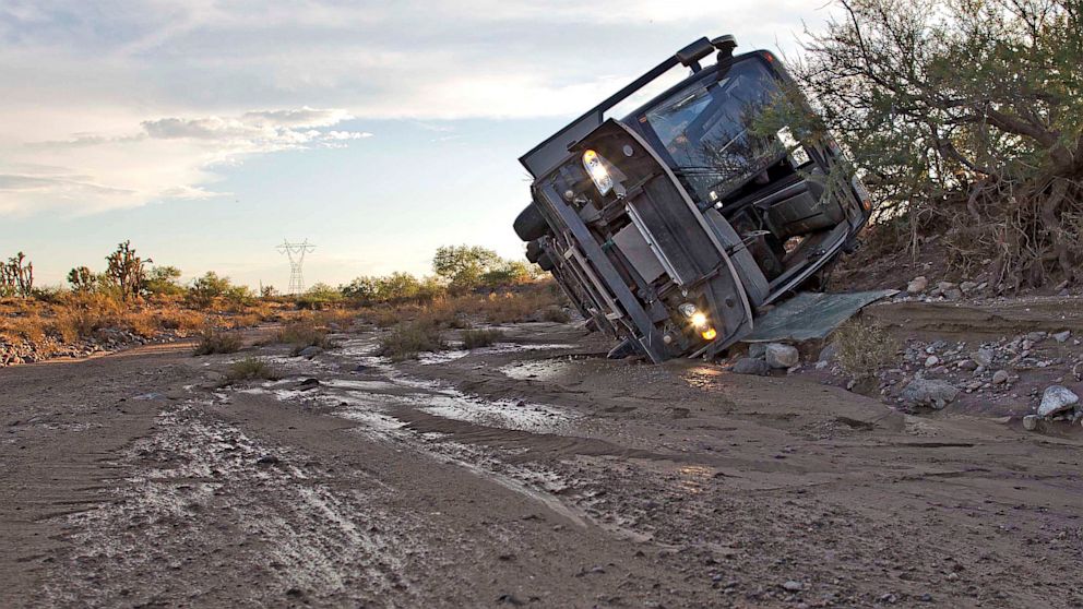 PHOTO: A tour bus lays on its side up against a bank of a wash, July 28, 2013, near Dolan Springs, Ariz.