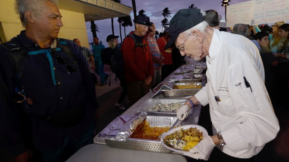 PHOTO: Homeless advocate Arnold Abbott, 90, director of the nonprofit group Love Thy Neighbor Inc., right, serves food to the homeless from a public parking lot next to the beach,Nov. 5, 2014, in Fort Lauderdale, Fla. 
