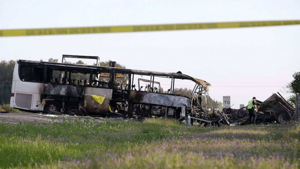 PHOTO: A California Highway Patrol Officer looks over the demolished cab of FedEx truck that crashed into a tour bus, at left, on Interstate 5 Thursday in Orland, Calif., April 11, 2014.