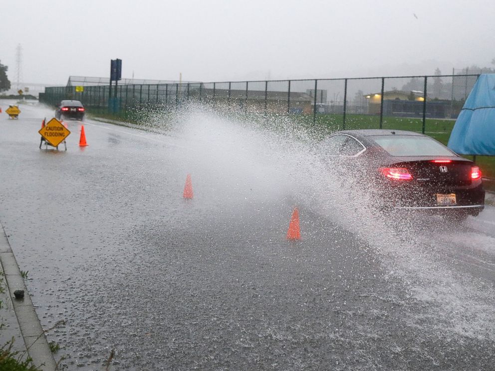 PHOTO: A car creates a wave of water while passing through a flooded area, Dec. 11, 2014, in Mill Valley, Calif.