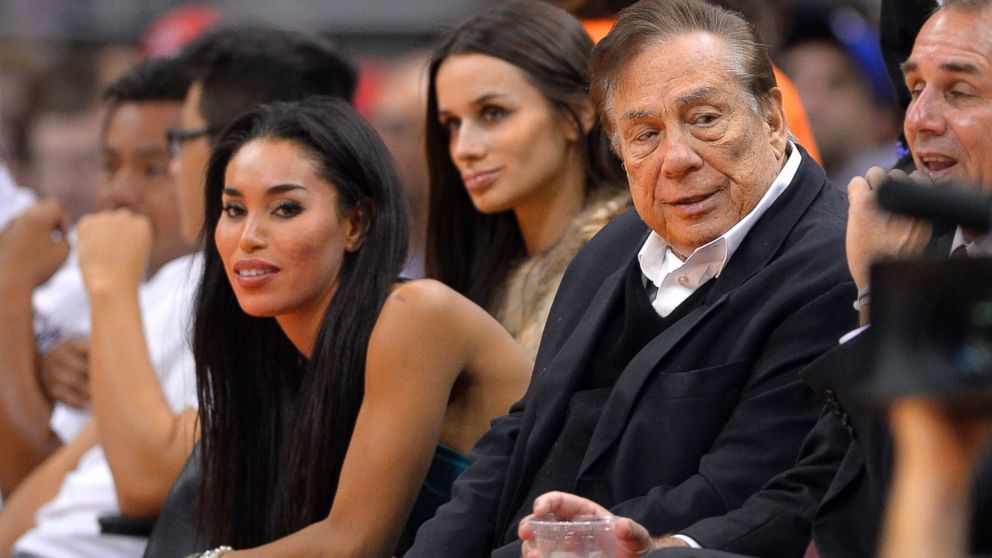 PHOTO: Los Angeles Clippers owner Donald Sterling and V. Stiviano, seated to his right, watch the Clippers play the Sacramento Kings, Oct. 25, 2013, in Los Angeles.