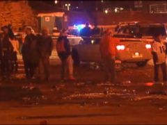 PHOTO: People hang around the area where three people were stabbed, Dec. 12, 2013, in a parking lot at Sports Authority Stadium Field after the Denver Broncos game.