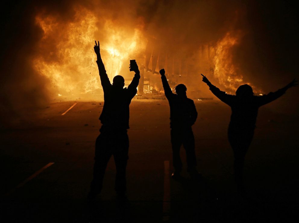 PHOTO: People watch as stores burn, Nov. 25, 2014, in Ferguson, Mo.