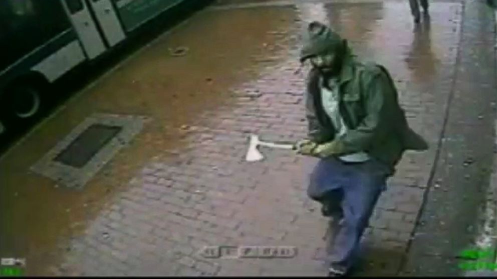 PHOTO: In a frame grab taken from surveillance video by the New York City Police Department, an unidentified man approaches New York City police officers with a hatchet in the citys Queens borough, Oct. 23, 2014.