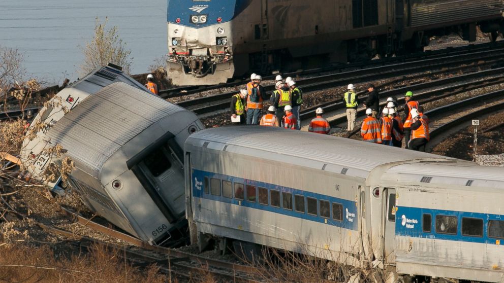 PHOTO: An Amtrak train traveling on an unaffected track, passes a derailed Metro North commuter train, Dec. 1, 2013, in the Bronx, New York.
