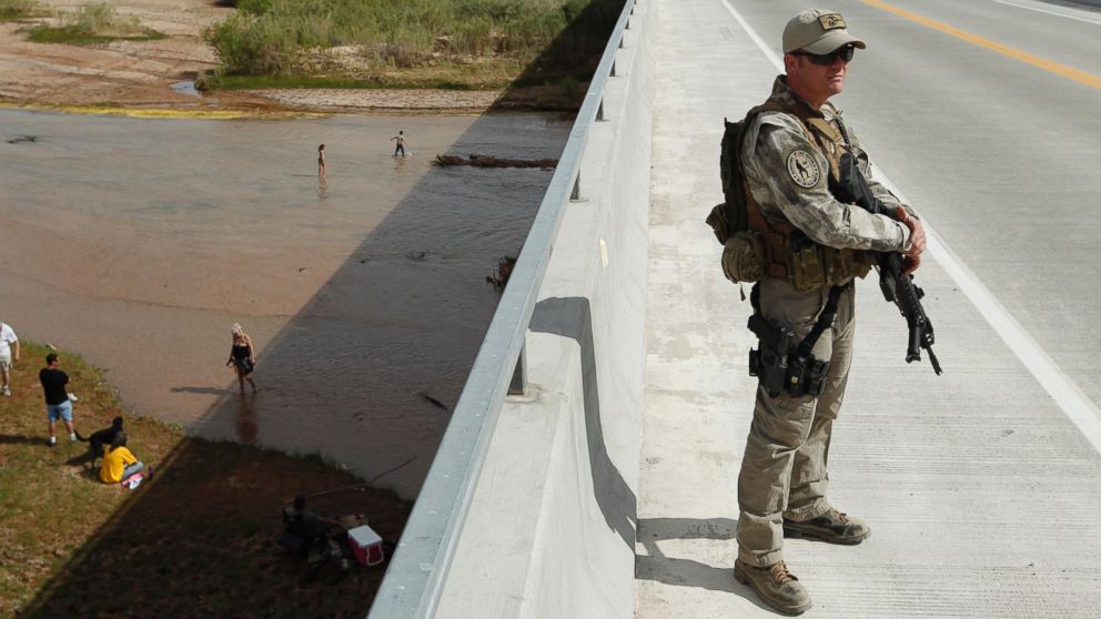 PHOTO: Justin Giles of Wasilla, Alaska stands guard on a bridge over the Virgin River during a rally in support of Cliven Bundy near Bunkerville, Nev. Friday, April 18, 2014.