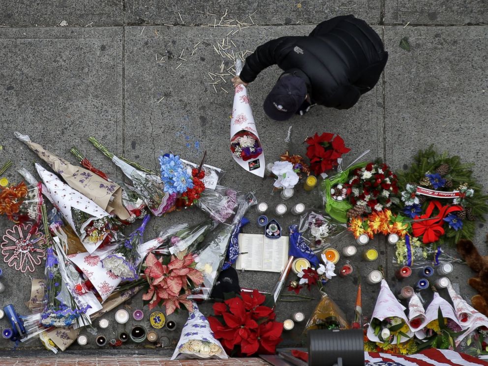 PHOTO: A man leaves flowers at an impromptu memorial near the site where two police officers were killed the day before in the Brooklyn borough of New York, Dec. 21, 2014. 